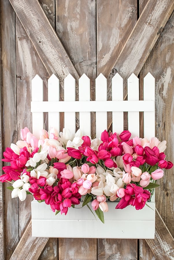 White picket fence wreath filled with pink and white tulips