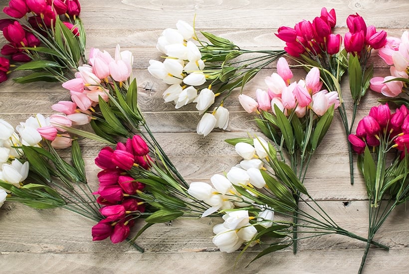 pink and white tulip sprigs spread on a wooden board