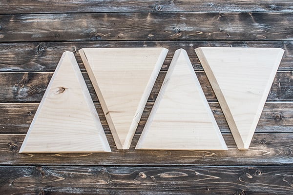 Triangle wood cut outs laid out on a wood board