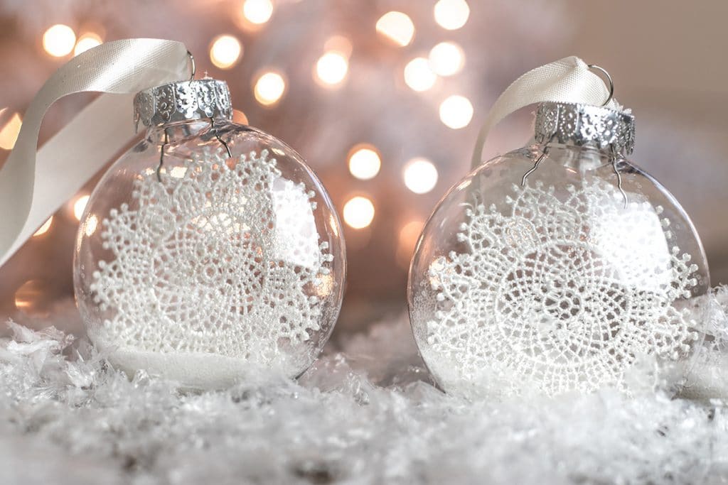 Two trapped snowflake ornaments resting on fake snow.