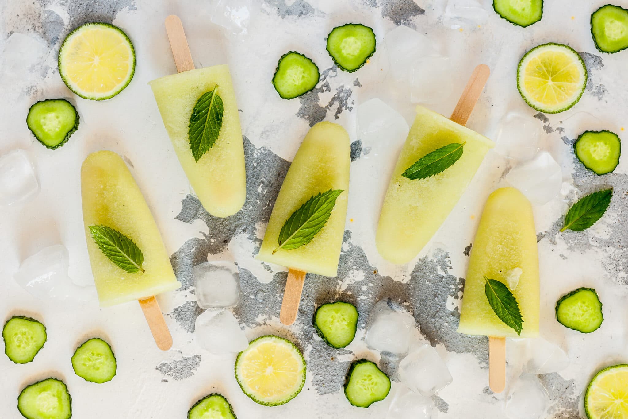 Mojito popsicles surrounded by sliced cucumber.