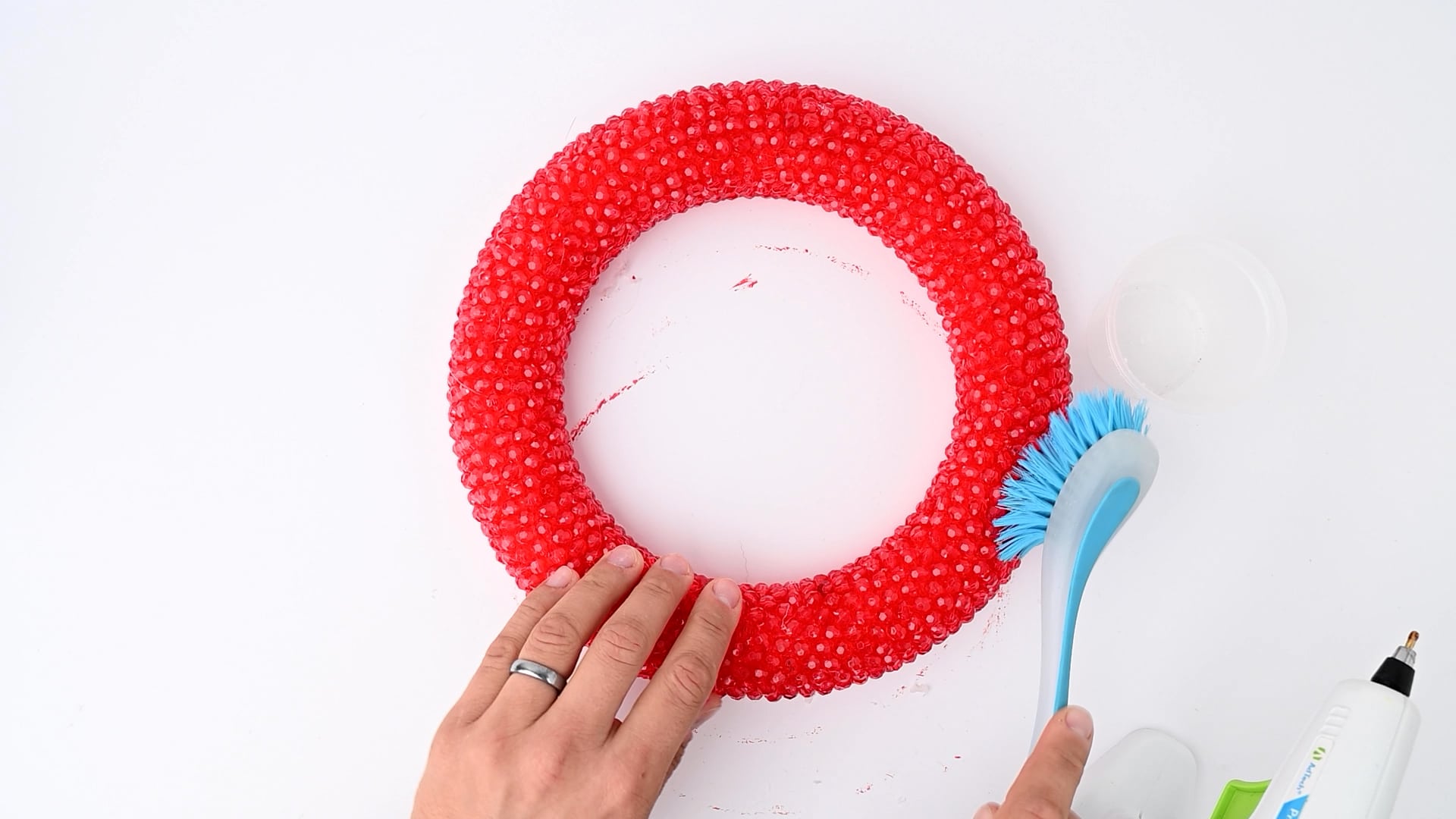 Use a soft brush to remove hot glue "webs" from your beaded wreath. 