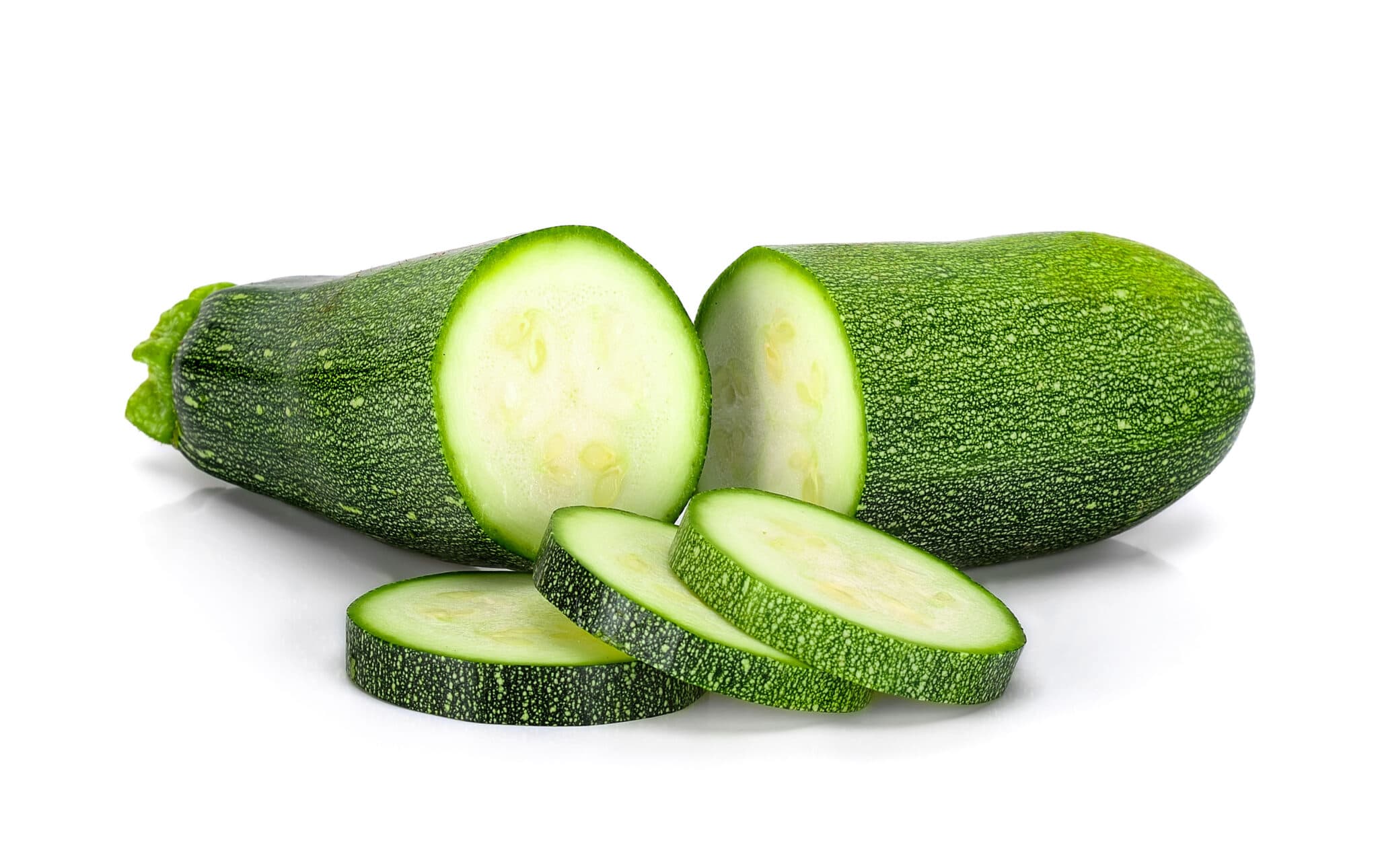 Small harvested bright green zucchini against a bright white background. The image is intended to help identify the fastest growing vegetables in the garden. 