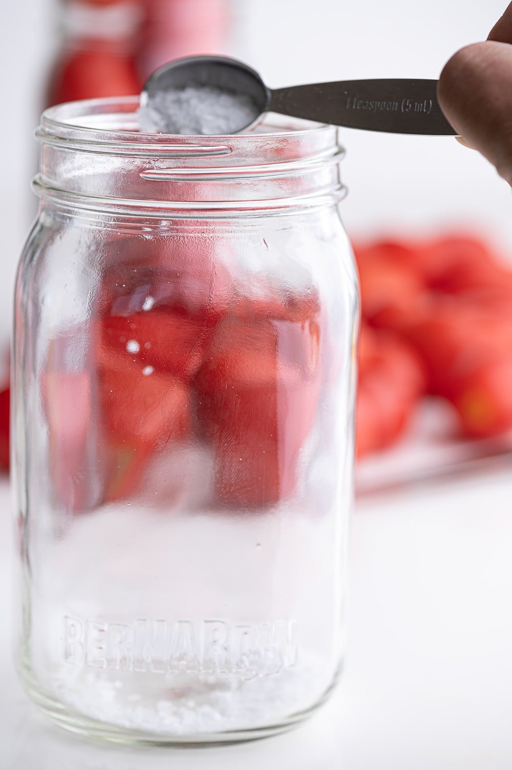 A clean quart jar with salt being added.